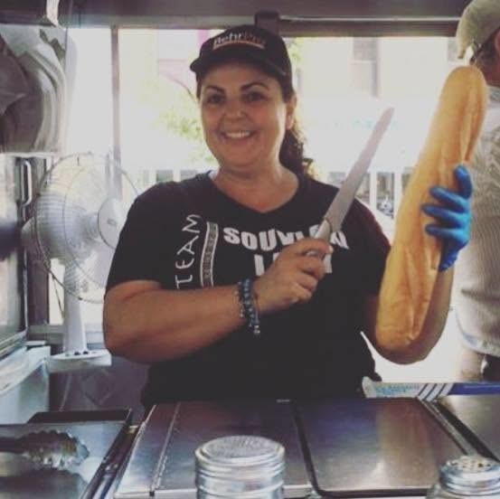 Elpida, the Souvlaki Lady, smiling at the cart