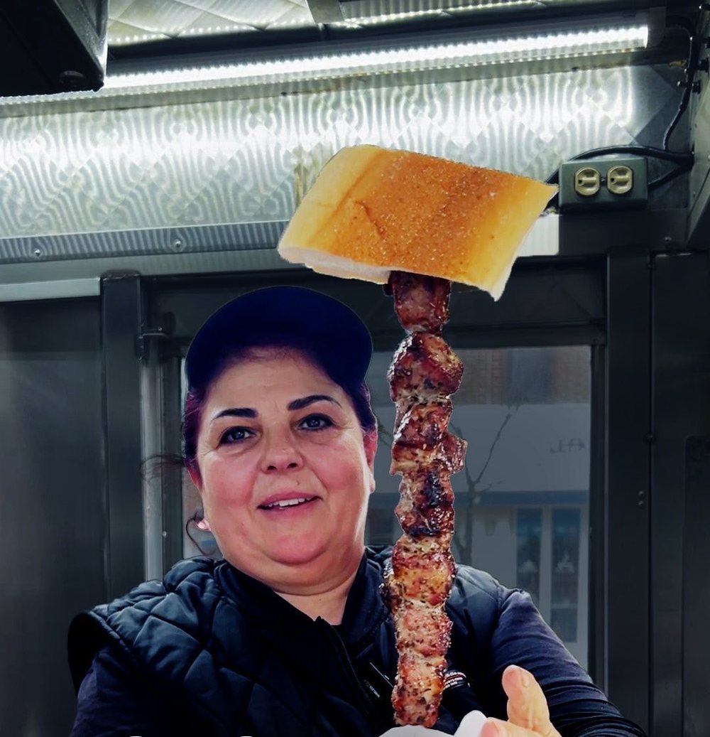 Elpida handing a pork souvlaki skewer with grilled bread across the counter